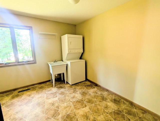 washroom featuring stacked washer and dryer and sink