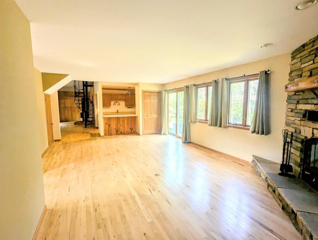 unfurnished living room with a fireplace and light hardwood / wood-style flooring