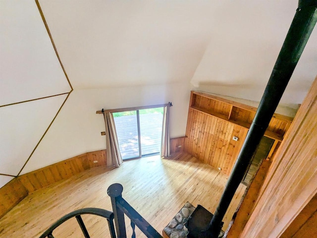 additional living space with hardwood / wood-style flooring and wooden walls