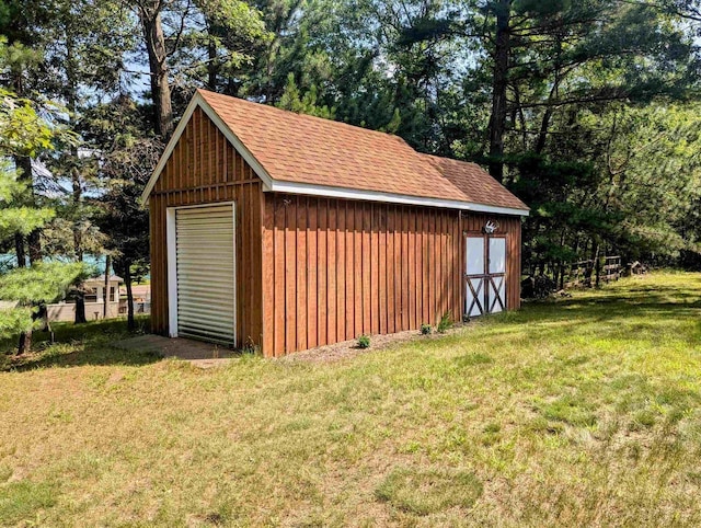 view of outdoor structure with a garage and a lawn