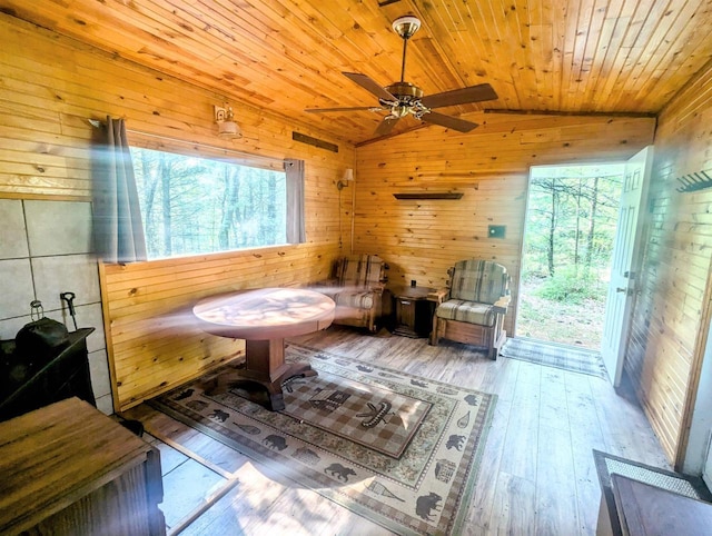 sitting room featuring lofted ceiling, wooden ceiling, wooden walls, and light hardwood / wood-style flooring