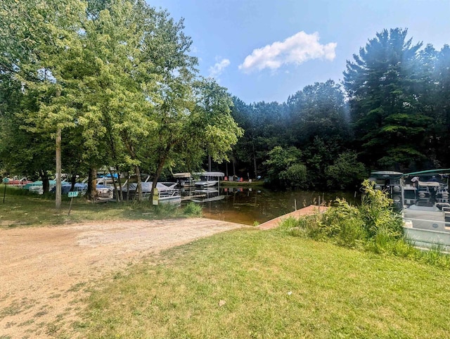 view of yard featuring a boat dock and a water view