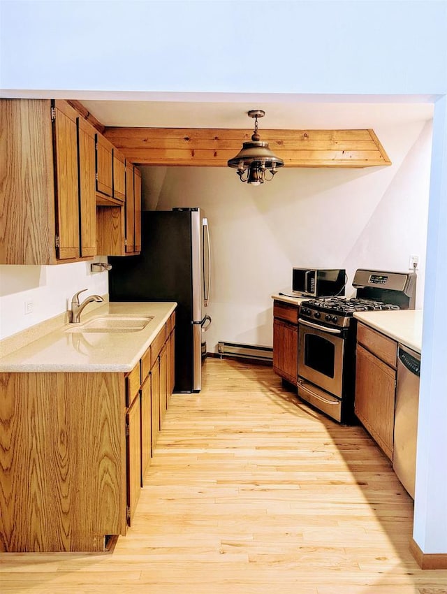 kitchen with sink, stainless steel appliances, baseboard heating, and light wood-type flooring