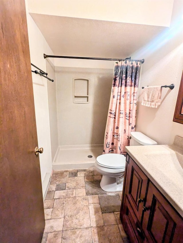 bathroom with vanity, curtained shower, and toilet