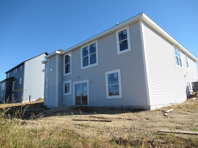 rear view of house featuring central air condition unit