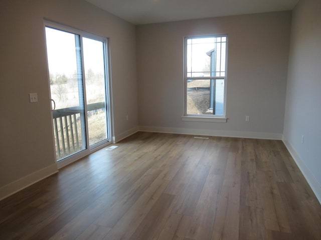 1790 Arbor Vista Pl, West Bend, WI 53095 - unfurnished room featuring healthy amount of natural light, wood finished floors, and baseboards