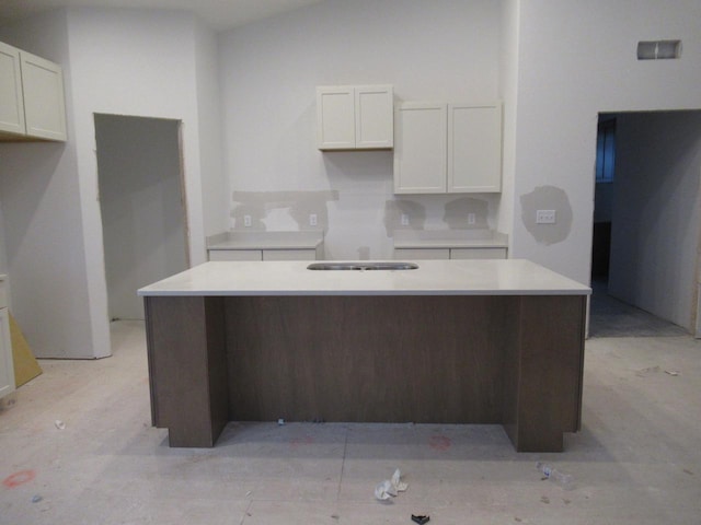 kitchen with white cabinetry, vaulted ceiling, and a center island