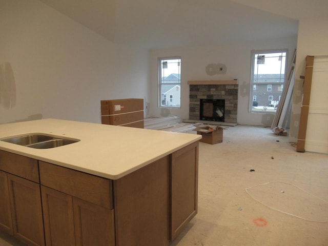 1790 Arbor Vista Pl, West Bend, WI 53095 - kitchen featuring open floor plan, a stone fireplace, light countertops, plenty of natural light, and vaulted ceiling