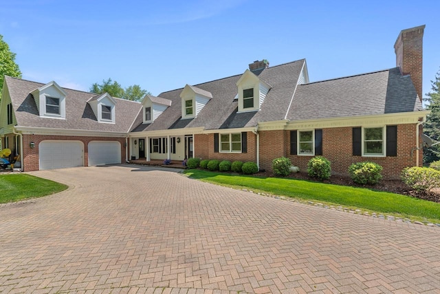 new england style home with a garage and a front yard