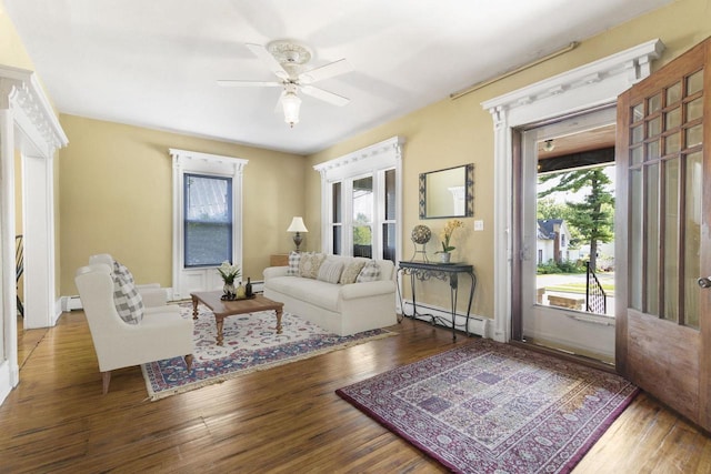 living room featuring a baseboard radiator, hardwood / wood-style floors, and a wealth of natural light