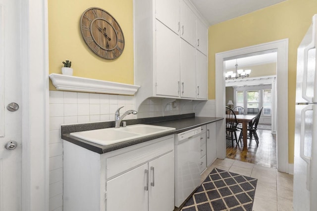 kitchen with sink, white cabinets, decorative backsplash, light tile patterned floors, and white appliances