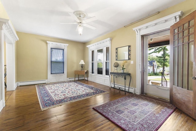 foyer featuring baseboard heating, ceiling fan, and wood-type flooring