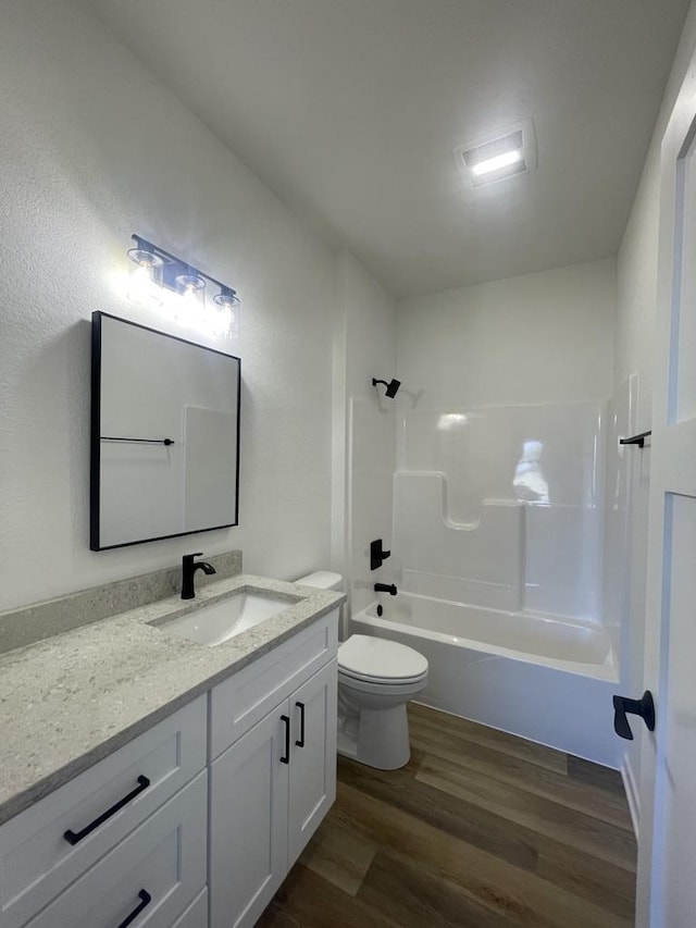 full bathroom with toilet, hardwood / wood-style floors, vanity, and shower / bathing tub combination