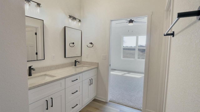 716 Kelsey Rd, Beloit, WI 53511 - bathroom featuring wood finished floors, ceiling fan, a sink, and double vanity