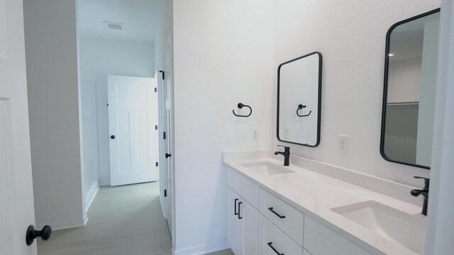3272 S Bartells Dr, Beloit, WI 53511 - full bathroom featuring double vanity, visible vents, baseboards, and a sink
