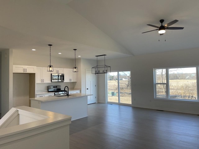 kitchen featuring open floor plan, light countertops, an island with sink, appliances with stainless steel finishes, and white cabinets