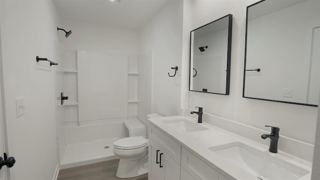 bathroom featuring walk in shower, wood-type flooring, toilet, and vanity