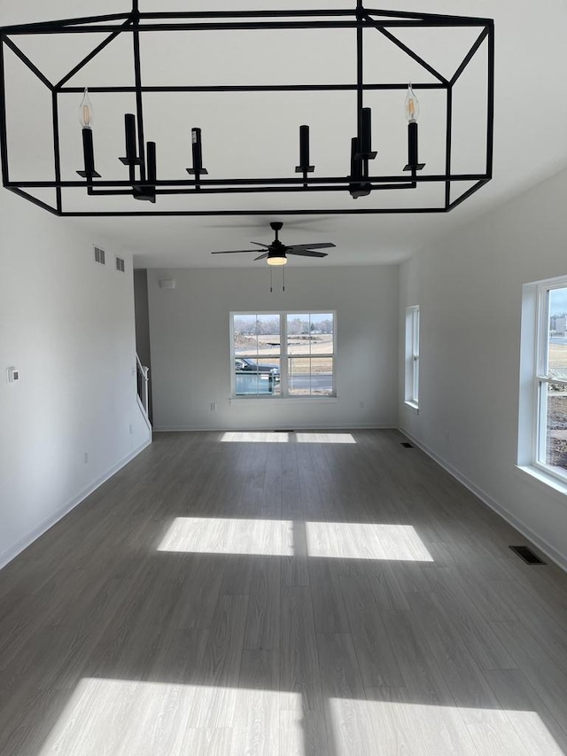 unfurnished living room featuring ceiling fan, hardwood / wood-style floors, and a high ceiling