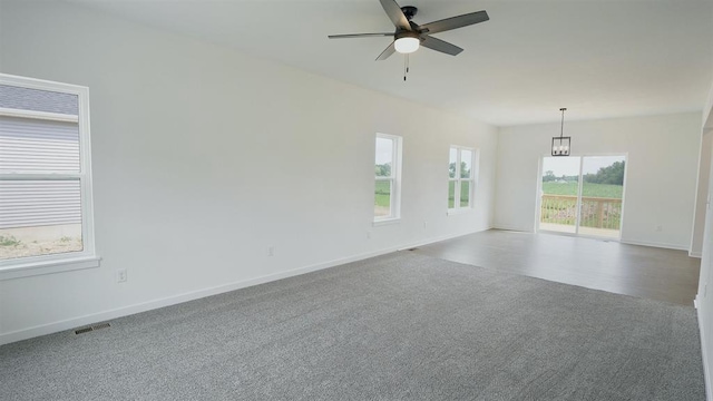 empty room featuring carpet flooring and ceiling fan with notable chandelier