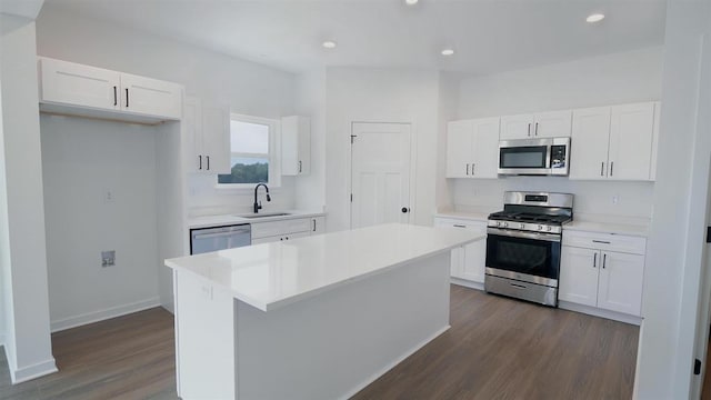 kitchen featuring dark wood-type flooring, sink, white cabinetry, a center island, and appliances with stainless steel finishes