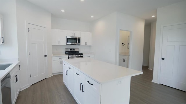 kitchen featuring sink, a center island, stainless steel appliances, hardwood / wood-style floors, and white cabinets