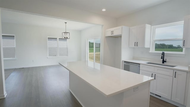 kitchen featuring white cabinetry, stainless steel dishwasher, a center island, and sink