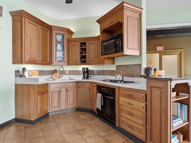 834 N Water St, Sheboygan, WI 53081 - kitchen featuring light tile patterned floors, kitchen peninsula, sink, and black appliances