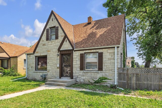 tudor-style house featuring a front yard