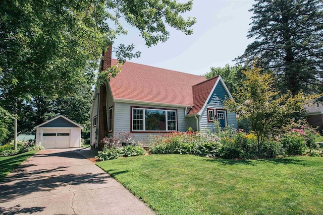 view of front of house with a garage, an outbuilding, and a front yard