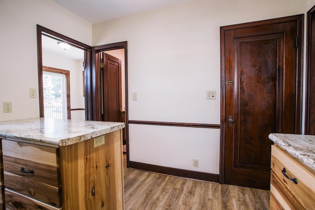 kitchen with light stone countertops and dark hardwood / wood-style floors