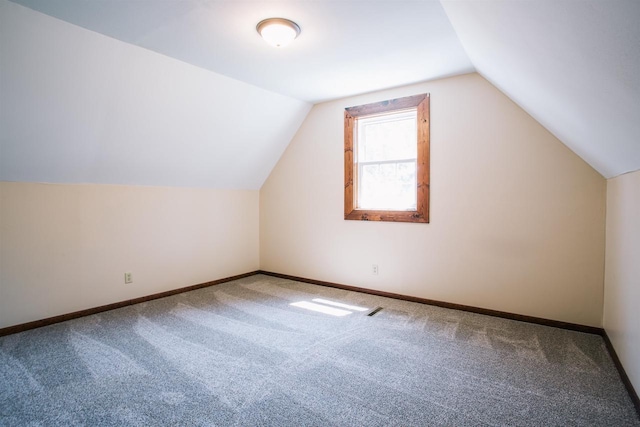 bonus room with vaulted ceiling and carpet