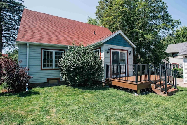 rear view of property featuring a wooden deck and a yard