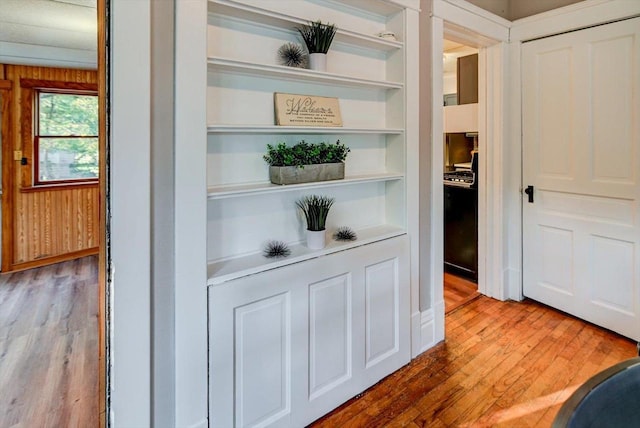 corridor with wooden walls and hardwood / wood-style flooring