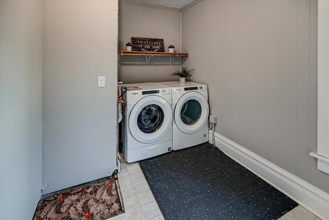 laundry area featuring wood walls and washer and clothes dryer