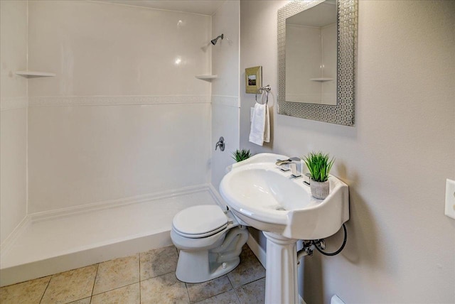 bathroom with a shower, toilet, and tile patterned floors