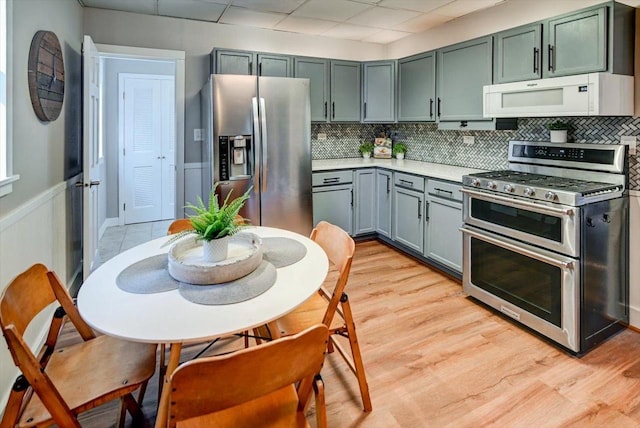 kitchen with backsplash, light hardwood / wood-style flooring, and stainless steel appliances