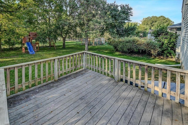 wooden deck featuring a playground and a yard