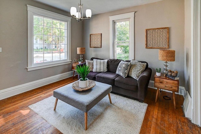 living room featuring a notable chandelier and dark wood-type flooring