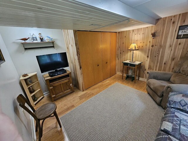 living room with wood walls and light hardwood / wood-style flooring