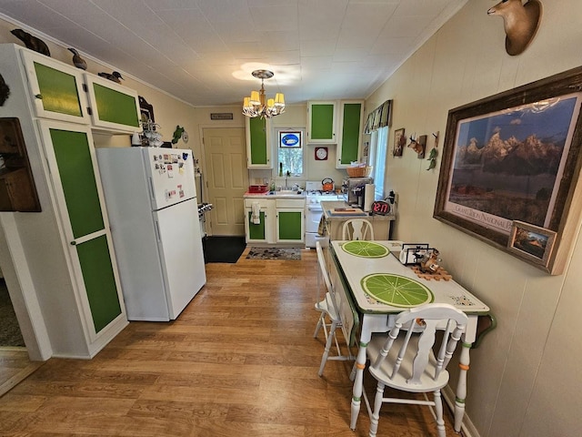 kitchen featuring green cabinetry, light wood-type flooring, a notable chandelier, and white refrigerator