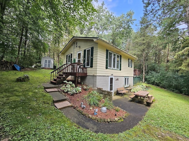 view of side of home with a storage unit and a lawn