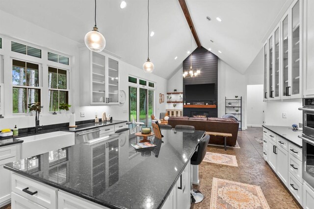 kitchen with sink, white cabinetry, high vaulted ceiling, hanging light fixtures, and beamed ceiling