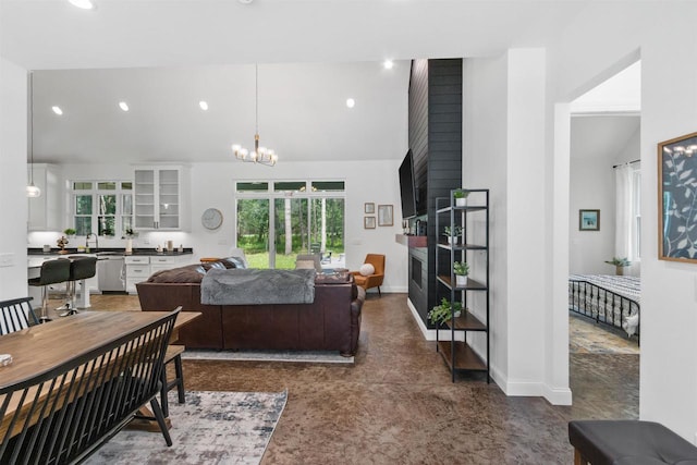 living room with sink, a chandelier, and vaulted ceiling