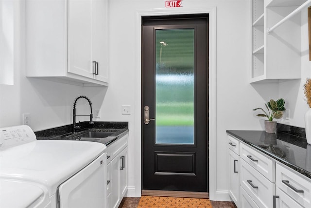 washroom with cabinets, washer and dryer, and sink