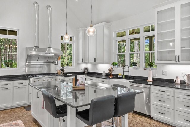 kitchen with dishwasher, sink, white cabinets, and a kitchen breakfast bar