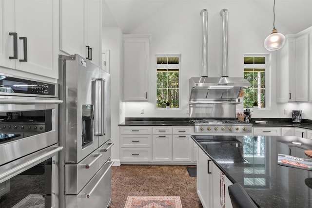 kitchen featuring white cabinetry, a wealth of natural light, dark stone counters, and appliances with stainless steel finishes