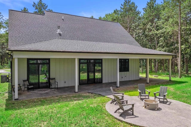 back of house with a fire pit, a lawn, central AC, and a patio area