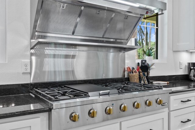 kitchen with stainless steel gas cooktop, white cabinets, and dark stone counters