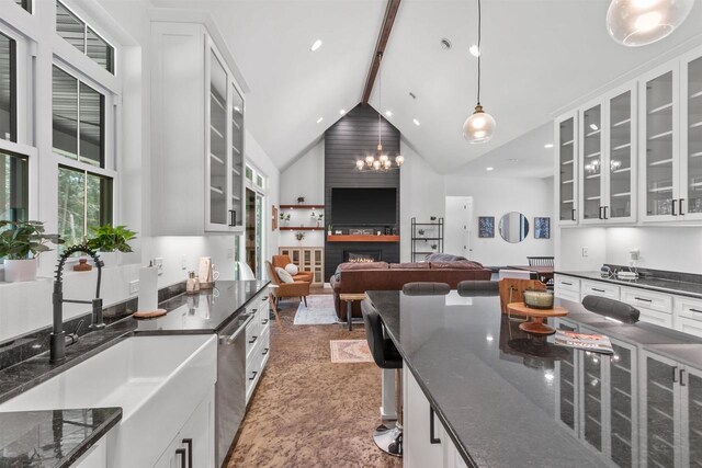 kitchen featuring beam ceiling, decorative light fixtures, high vaulted ceiling, and white cabinets