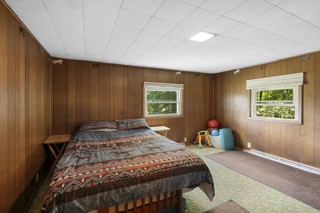 carpeted bedroom with multiple windows and a baseboard heating unit